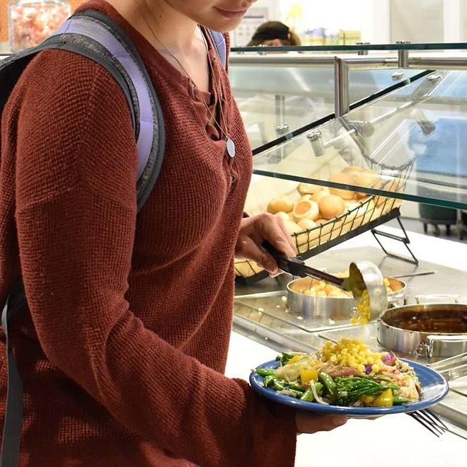 Student filling plate at campus restaurant